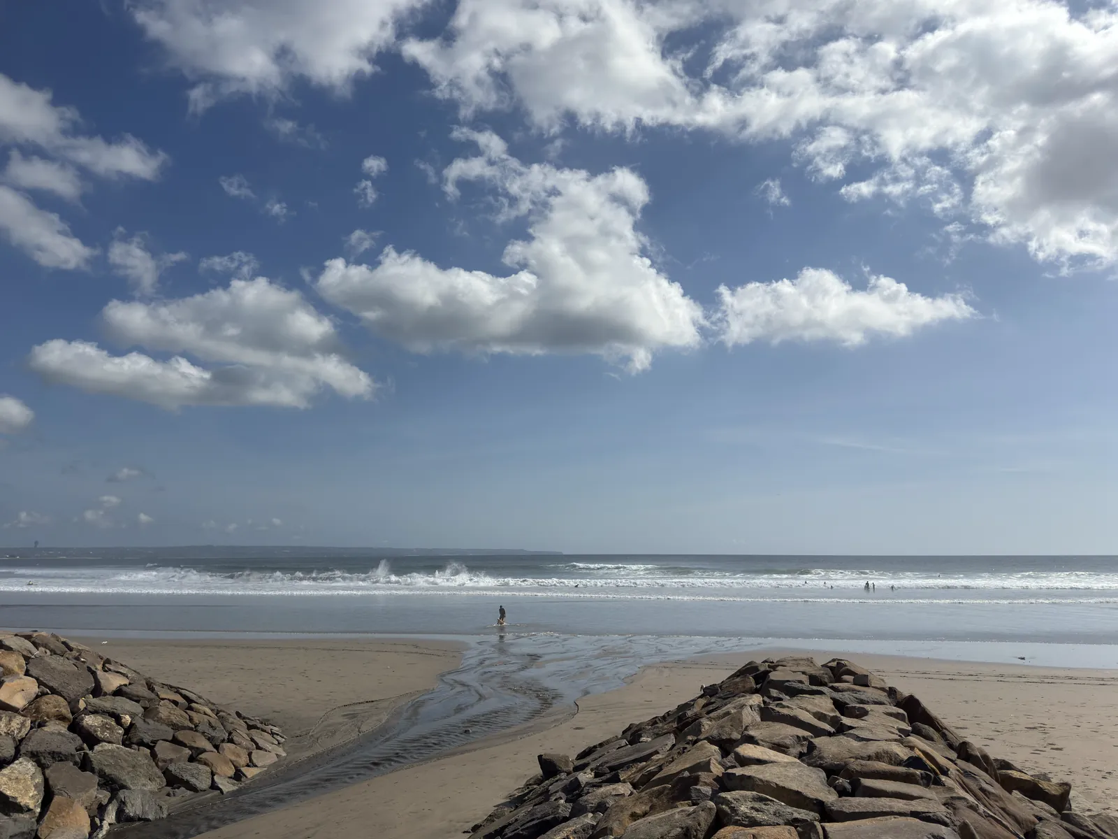 A stone breakwater on the beach near Oberoi