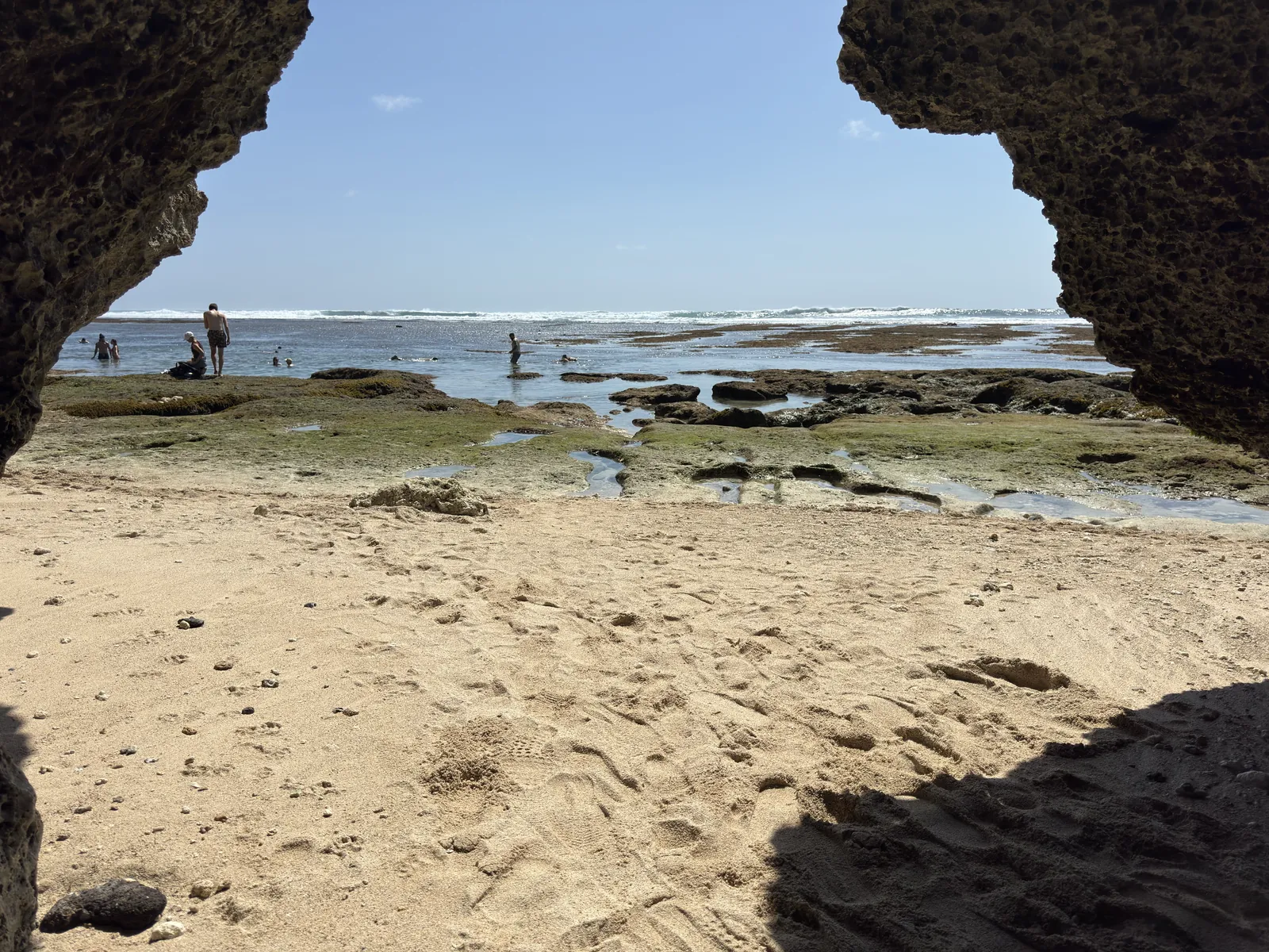 The beach at Padang Padang seen through a rock arch